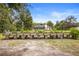 A wide shot of a large raised garden bed set in a spacious backyard with a home and screened enclosure in the background at 940 Glenwood Rd, Deland, FL 32720