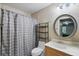 Cozy bathroom with a shower, gray curtain, vanity, and a round mirror at 944 Regatta Bay Dr # 12-102, Orange City, FL 32763