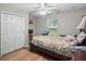 A bedroom with wood floors, a window, and a closet with white doors at 944 Regatta Bay Dr # 12-102, Orange City, FL 32763