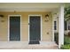 Up-close view of the doorways to units 102 and 202 with neutral siding and black doors at 944 Regatta Bay Dr # 12-102, Orange City, FL 32763
