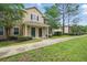 View of a tan two-story townhome showcasing a well-maintained landscape with a concrete pathway at 944 Regatta Bay Dr # 12-102, Orange City, FL 32763