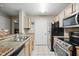 Well-lit kitchen featuring granite countertops, stainless steel appliances, and tile flooring at 944 Regatta Bay Dr # 12-102, Orange City, FL 32763