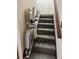 Stair lift offers accessibility on carpeted stairs with wooden railing on the side at 96 Old Barn Trl, Ormond Beach, FL 32174