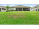 Spacious backyard with lush green grass, mature shrubbery, and a screened-in patio at 978 Victoria Hills S Dr, Deland, FL 32724
