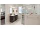 Bright bathroom features a glass shower, dual vanity with dark cabinets and marble-like tile floors at 978 Victoria Hills S Dr, Deland, FL 32724