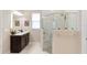 Bright bathroom features a glass shower, dual vanity with dark cabinets and marble-like tile floors at 978 Victoria Hills S Dr, Deland, FL 32724