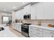 Modern white kitchen featuring stainless steel appliances, a stylish backsplash, and plenty of counter space at 978 Victoria Hills S Dr, Deland, FL 32724