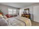 Bright bedroom featuring a large bed with patterned bedding, a dresser, and a cozy chair near the window at 10 Lynnhurst Dr # 1050, Ormond Beach, FL 32176