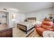 Well-lit bedroom with wood-look flooring, a cozy chair, a bed with decorative pillows, and a floor lamp at 10 Lynnhurst Dr # 1050, Ormond Beach, FL 32176