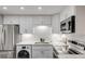 Modern kitchen features stainless steel refrigerator, quartz countertops, white cabinets, and a built-in laundry unit at 10 Lynnhurst Dr # 1050, Ormond Beach, FL 32176