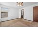 Bright bedroom with a window, neutral carpet, and a glimpse into an ensuite bathroom at 1018 E Gaucho Cir, Deltona, FL 32725