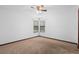 A carpeted bedroom with white walls and a window allowing natural light at 1018 E Gaucho Cir, Deltona, FL 32725