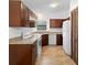 Traditional kitchen featuring white appliances, dark cabinets, and tile floors at 1018 E Gaucho Cir, Deltona, FL 32725