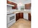 A well-lit kitchen featuring dark cabinets and modern white appliances and neutral countertops and flooring at 1018 E Gaucho Cir, Deltona, FL 32725