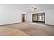 Spacious living room with plush carpeting, neutral walls, and sliding glass doors to the lanai at 1018 E Gaucho Cir, Deltona, FL 32725