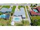 An aerial perspective displays a property with a pool, fenced yard, long driveway, and lush greenery at 1027 Bel Aire Dr, Daytona Beach, FL 32118
