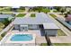 An elevated shot showcases a pool home with lush landscaping and a patterned tile patio and driveway at 1027 Bel Aire Dr, Daytona Beach, FL 32118