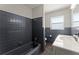 Bathroom features dark gray tiles, a modern vanity, and updated fixtures at 1027 Bel Aire Dr, Daytona Beach, FL 32118