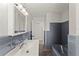 Bathroom with gray tiles, a large vanity, updated lighting, and modern fixtures at 1027 Bel Aire Dr, Daytona Beach, FL 32118