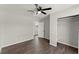 Bedroom featuring gray wood floors, neutral walls, a ceiling fan, and closet space at 1027 Bel Aire Dr, Daytona Beach, FL 32118