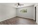 Bedroom with gray wood floors, neutral walls, a ceiling fan, and a bright window at 1027 Bel Aire Dr, Daytona Beach, FL 32118