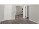 A welcoming view from the entry way featuring a white door and durable, wood-look flooring, leading into the refreshed kitchen at 1027 Bel Aire Dr, Daytona Beach, FL 32118