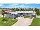 A front elevated view displays a grey home with a driveway and lush lawn at 1027 Bel Aire Dr, Daytona Beach, FL 32118