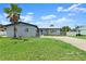Charming single-story home features a well-manicured lawn, palm tree, and a long driveway at 1027 Bel Aire Dr, Daytona Beach, FL 32118