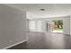 A spacious living room features a sliding glass door leading to the yard and light gray walls with durable, wood-look flooring at 1027 Bel Aire Dr, Daytona Beach, FL 32118