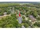 Overhead shot showcasing a house with a pool, located in a tree-filled neighborhood with nearby amenities at 1205 Weeping Willow Dr, Deland, FL 32724