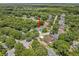 An aerial view shows the home nestled among mature trees in a quiet neighborhood at 1205 Weeping Willow Dr, Deland, FL 32724