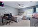 Functional bedroom space includes a ceiling fan, a desk with computer, and a comfortable bed with a nightstand at 1205 Weeping Willow Dr, Deland, FL 32724