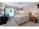 Bright bedroom featuring a ceiling fan, neutral walls, and a cozy bed with decorative pillows and beach-themed accents at 1205 Weeping Willow Dr, Deland, FL 32724