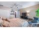 Comfortable bedroom with ceiling fan, chair, closet, and view into another room, offering a relaxing and functional space at 1205 Weeping Willow Dr, Deland, FL 32724