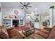 Open concept living room with hardwood floors, ceiling fan, bookcase, and an open view to the kitchen at 1205 Weeping Willow Dr, Deland, FL 32724