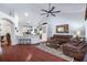 Open concept living room with hardwood floors, ceiling fan, and kitchen view at 1205 Weeping Willow Dr, Deland, FL 32724