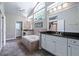 Bright main bathroom featuring a garden tub, tiled floors, double sink vanity and large windows at 1205 Weeping Willow Dr, Deland, FL 32724