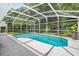 Screened-in pool with a well-maintained concrete deck and lush landscaping at 1205 Weeping Willow Dr, Deland, FL 32724