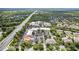 Aerial view showcasing a well-developed commercial area surrounded by lush greenery, a highway and residential neighborhoods at 1227 Victoria Hills N Dr, Deland, FL 32724