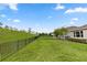 Large grassy backyard enclosed by a sleek, black iron fence at 1227 Victoria Hills N Dr, Deland, FL 32724