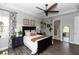 Bright bedroom with a black bed frame, ceiling fan, and decorative plants at 1227 Victoria Hills N Dr, Deland, FL 32724