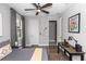 Well-lit bedroom featuring a ceiling fan, wood floors, and a convenient workspace area at 1227 Victoria Hills N Dr, Deland, FL 32724
