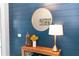 Foyer console table decor with a round mirror, decorative lamp, and navy blue wall at 1227 Victoria Hills N Dr, Deland, FL 32724