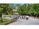 Neatly parked golf carts on a paved lot surrounded by mature trees and lush landscaping near the golf course at 1227 Victoria Hills N Dr, Deland, FL 32724