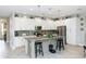Bright kitchen with white cabinets, granite countertops, an island with stools, and modern appliances at 1227 Victoria Hills N Dr, Deland, FL 32724