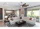 Bright living room featuring a sectional sofa, ceiling fan, and sliding glass doors to outdoor space at 1227 Victoria Hills N Dr, Deland, FL 32724