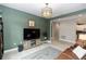 Living room with a media cabinet, grey rug, modern lighting and olive green walls at 1227 Victoria Hills N Dr, Deland, FL 32724