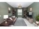 Cozy living room with a leather sofa, bookcases, and a grey rug at 1227 Victoria Hills N Dr, Deland, FL 32724