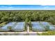 Overhead view of several tennis courts surrounded by lush greenery, providing a serene and active setting at 1227 Victoria Hills N Dr, Deland, FL 32724