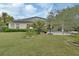 Spacious, landscaped backyard with a covered patio, palm trees, and a barbecue area at 1310 Pup Fish Ln, Deland, FL 32724